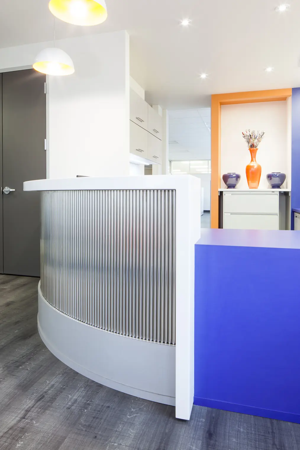 Custom commercial reception desk with blue accent panel by G&S Woodworking