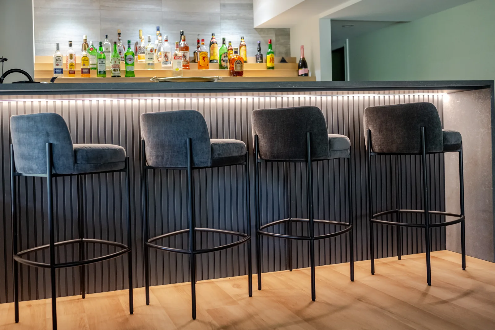 Custom home bar with backlit bottle display by G&S Woodworking